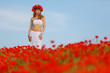 beauty woman in poppy field in white dress