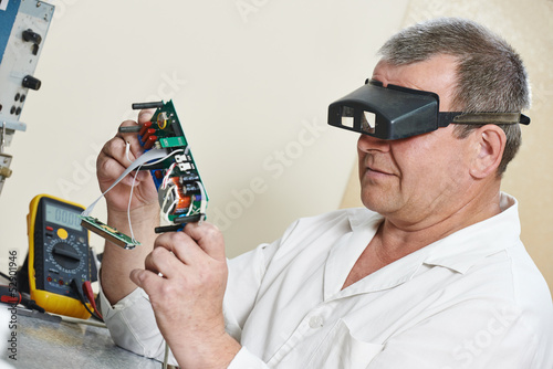 Photo: technician engineer at work with microchip technician engineer at work with microchip