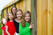 Grils group in a row smiling in a wooden fence