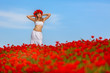 girl in a white dress in the poppy field