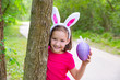 Photo: Easter girl with big purple egg and funny bunny ears Easter girl with big purple egg and funny bunny ears