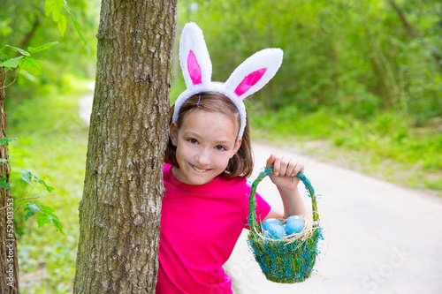 Photo: Easter girl with eggs basket and funny bunny face Easter girl with eggs basket and funny bunny face