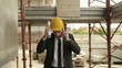 Engineer talking on mobile phone, walking in construction site