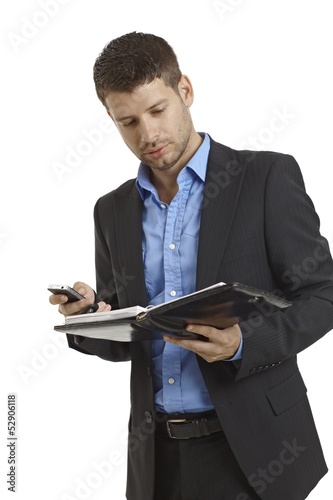 Photo: Young businessman looking at organizer Young businessman looking at organizer