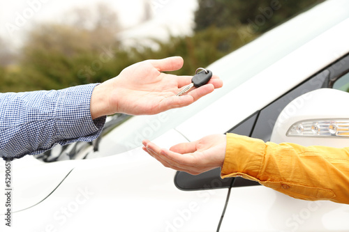 Photo: Woman and man hands with car key, close up Woman and man hands with car key, close up