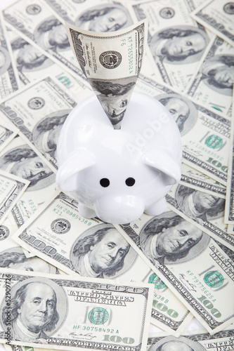 Photo: Piggy bank with a banknote against the dollar bills. Piggy bank with a banknote against the dollar bills.