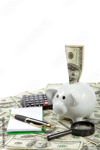 Photo: Piggy bank with a notebook, pen and calculator against the dolla Piggy bank with a notebook, pen and calculator against the dolla