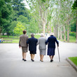 old women walking arm in arm in the park