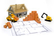 Foto: Miniziegelsteine auf Bauplan mit Baufahrzeugen und Haus Miniziegelsteine auf Bauplan mit Baufahrzeugen und Haus