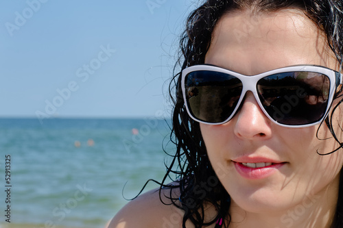 Photo: Woman in sunglasses posing at the sea Woman in sunglasses posing at the sea
