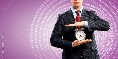 Photo: Business man holding alarmclock Business man holding alarmclock