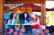 happy friends sitting on summer cafe terrace