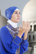 Attractive muslim girl praying at mosque