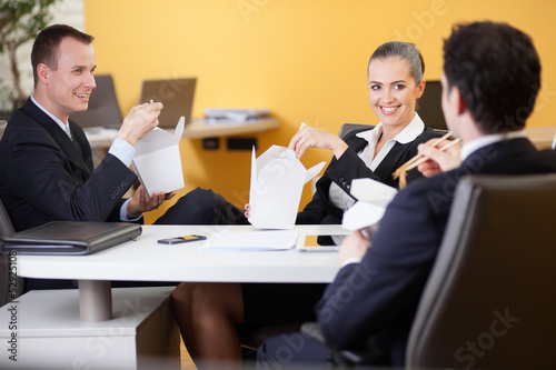 Photo: Business people eating chinese food in the office Business people eating chinese food in the office