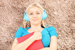 Blond smiling female with red notebook lying on a carpet