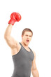 Photo: Happy male boxer wearing red boxing gloves and gesturing triumph Happy male boxer wearing red boxing gloves and gesturing triumph