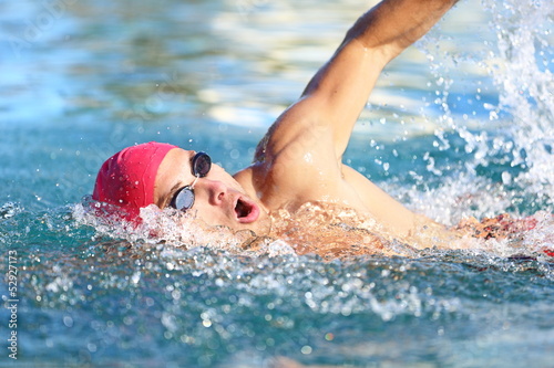 Photo: Man swimmer swimming crawl in blue water Man swimmer swimming crawl in blue water