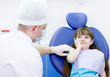 little girl holding her cheek with a toothache at dentist's offi