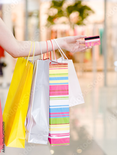 Photo: Female hand holding shopping bags and credit card Female hand holding shopping bags and credit card
