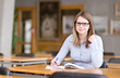 pretty young college student in a library looking at camera