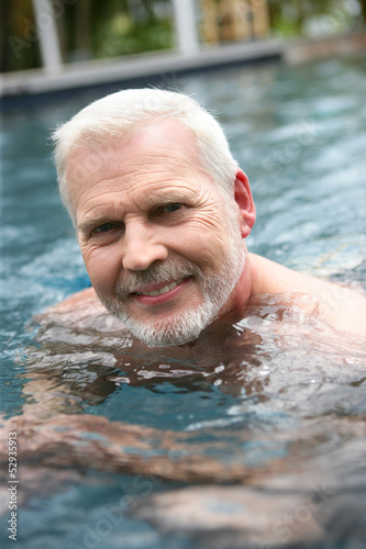 Photo: Grey-haired man swimming in the pool Grey-haired man swimming in the pool