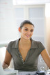 Foto: Casual office worker sat at her desk Casual office worker sat at her desk