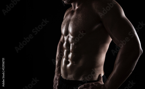 Photo: Close up of perfect male body isolated on black background Close up of perfect male body isolated on black background