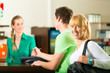 Men and women sign up at gym reception