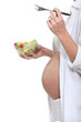 Photo: Cropped picture of a pregnant woman eating a salad. Cropped picture of a pregnant woman eating a salad.