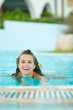 Photo: Smiling young woman swimming in pool Smiling young woman swimming in pool