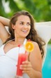 Photo: Happy young woman with cocktail laying on chaise-longue Happy young woman with cocktail laying on chaise-longue
