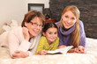 Photo: Grandmother, mother, and daughter lying on a bed Grandmother, mother, and daughter lying on a bed