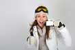 Cheerful skier woman showing ski pass