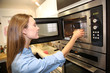 Photo: Woman heating dish in microwave Woman heating dish in microwave