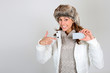 Beautiful girl in winter clothing showing ski pass