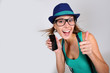 Foto: Funny girl with hat and eyeglasses showing smartphone Funny girl with hat and eyeglasses showing smartphone