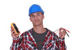 Foto: A wide-eyed tradesman holding a multimeter A wide-eyed tradesman holding a multimeter
