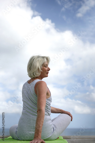 Photo: Senior woman doing yoga outdoors Senior woman doing yoga outdoors