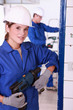 Photo: Young female electrician with a power drill Young female electrician with a power drill