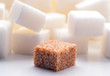one brown sugar lump in front of lots of white sugar cubes backl