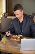 Businessman Using Mobilephone While Having Food