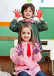 Foto: Boy And Girl Showing Colored Hands In Classroom Boy And Girl Showing Colored Hands In Classroom