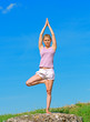 Meditation over sky background. Yoga woman on the hill.