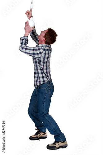 Photo: Man putting his finger in a light socket Man putting his finger in a light socket
