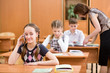 Photo: Primary school pupil using cell phone at lesson Primary school pupil using cell phone at lesson