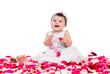 happy baby girl sitting among rose petals
