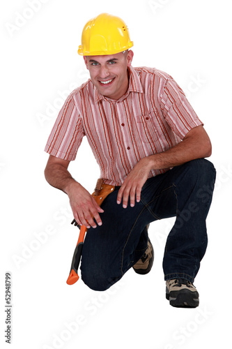 Photo: Portrait of a craftsman to his knees on the floor Portrait of a craftsman to his knees on the floor