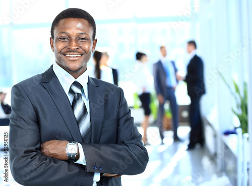 Photo: Confident business man with his team behind Confident business man with his team behind