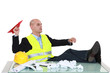 Photo: Bored foreman throwing paper airplane Bored foreman throwing paper airplane