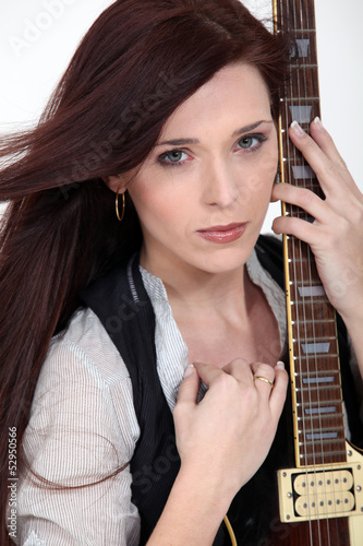 Photo: A woman holding a guitar. A woman holding a guitar.